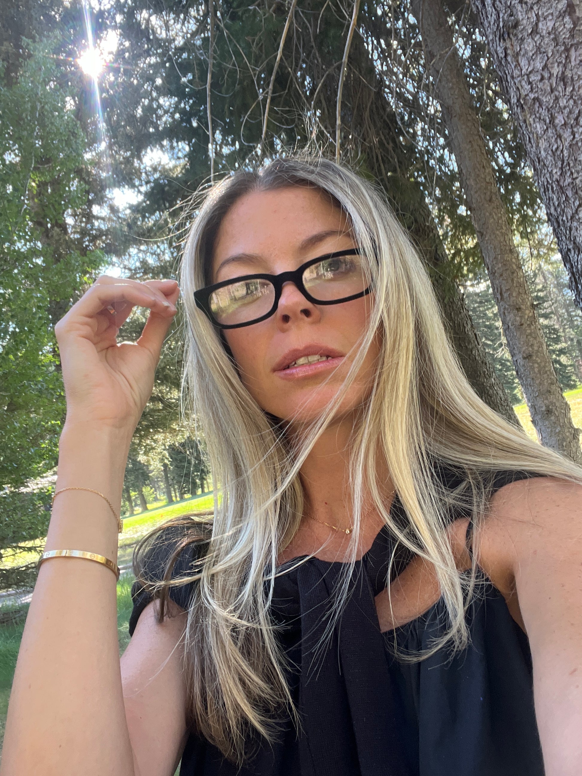 Woman in her 40s wearing black velvet Sydney reading glasses, photographed outdoors in Jackson, Wyoming