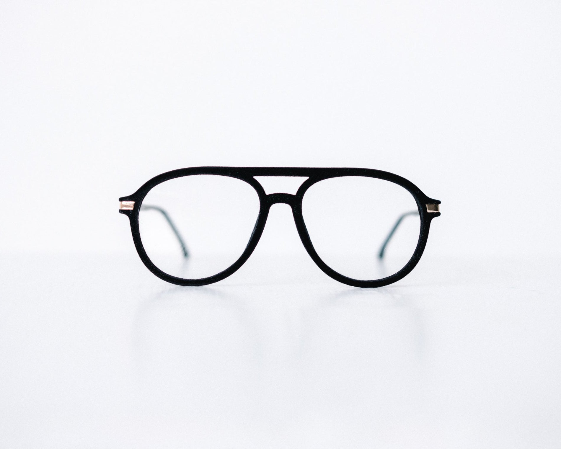 Front view of black velvet aviator glasses with matte black temples, displayed on a white background. The soft velvet texture gives a luxurious finish, available as reading glasses or blue light blocking glasses.