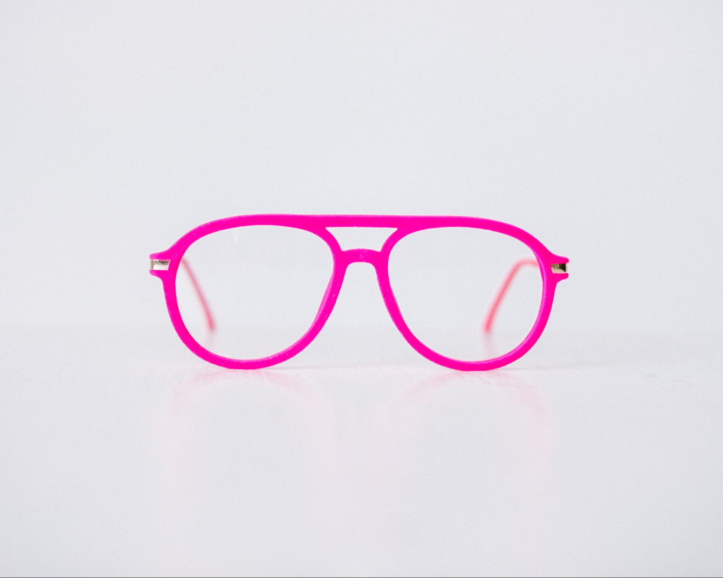Front view of pink velvet aviator reading glasses displayed on a white background, showing the soft velvet texture and sleek, modern silhouette.