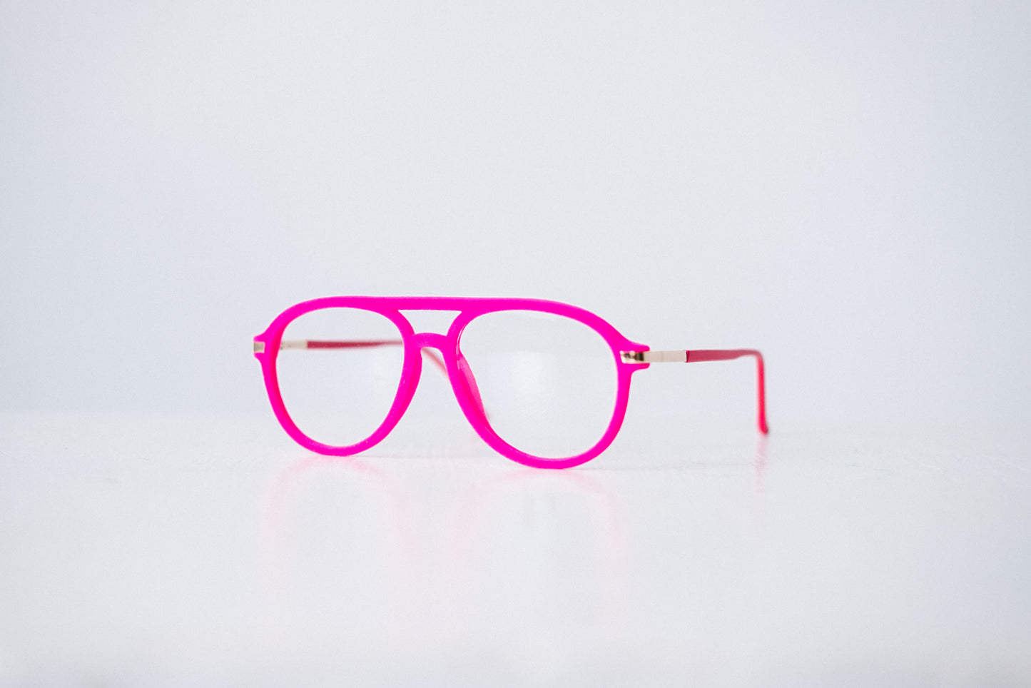 Side view of pink velvet aviator reading glasses displayed on a white background, showing the soft velvet texture and sleek, modern silhouette.