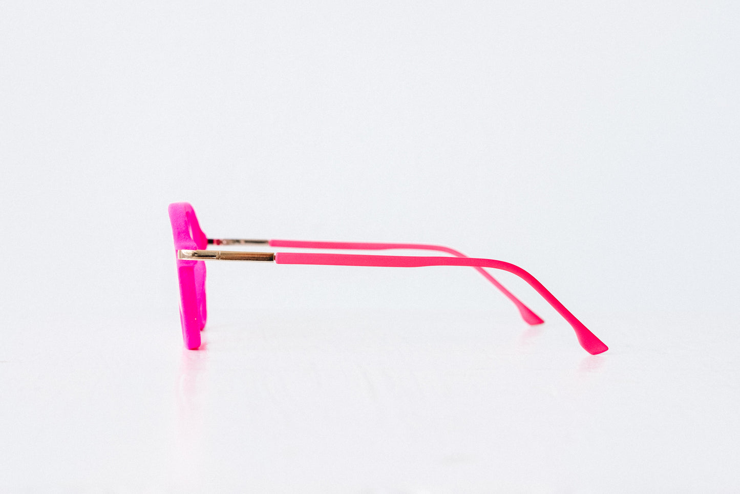 Side view of pink velvet aviator reading glasses displayed on a white background, showing the soft velvet texture and sleek, modern silhouette.