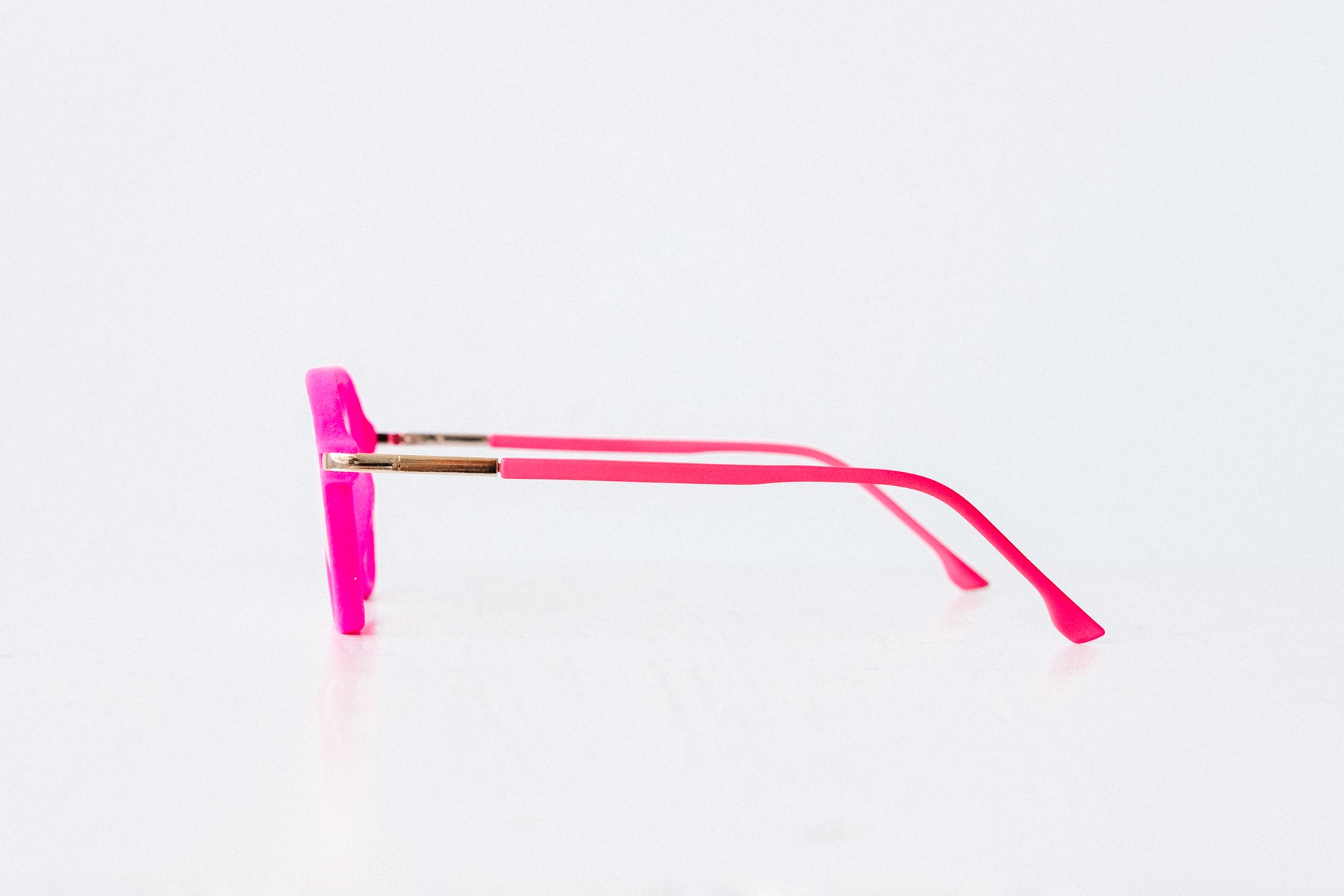 Side view of pink velvet aviator reading glasses displayed on a white background, showing the soft velvet texture and sleek, modern silhouette.