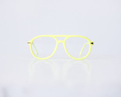 Front view of neon green and neon yellow velvet aviator glasses with matte temples, displayed on a white background. The bold, vibrant frame features a soft velvet texture and is available as reading glasses or blue light blocking glasses.