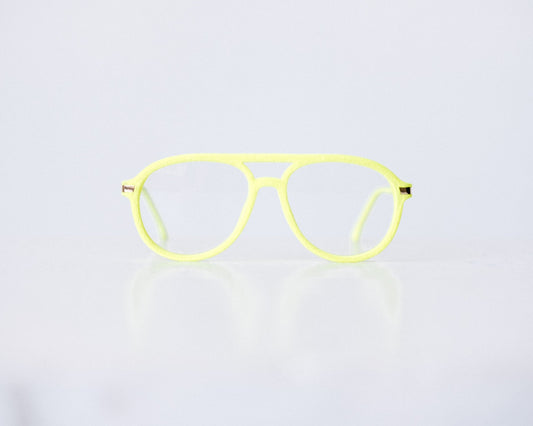 Front view of neon green and neon yellow velvet aviator glasses with matte temples, displayed on a white background. The bold, vibrant frame features a soft velvet texture and is available as reading glasses or blue light blocking glasses.