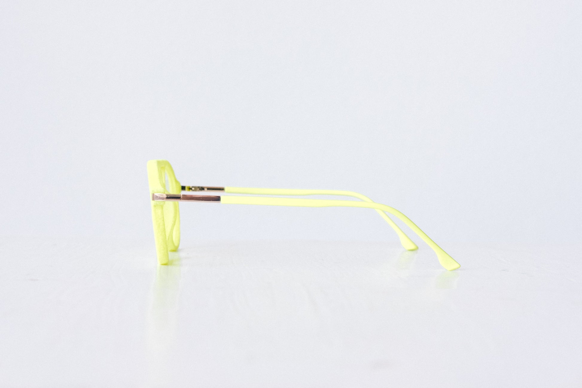 Side view of neon green and neon yellow velvet aviator glasses with matte temples, displayed on a white background. The bold, vibrant frame features a soft velvet texture and is available as reading glasses or blue light blocking glasses.