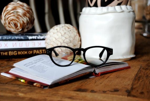Classic black round pantos acetate designer reading glasses on a book